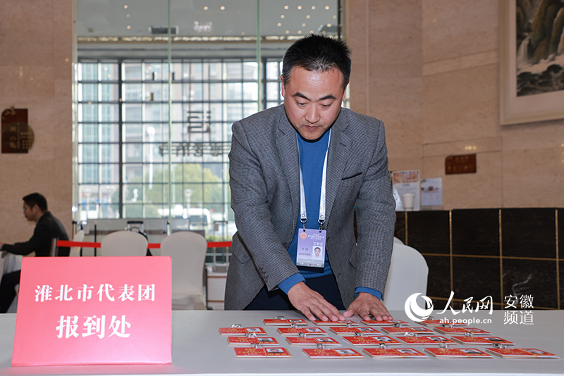 工作人員正在將證件擺放好，等待人大代表前來領(lǐng)取。人民網(wǎng)記者 王曉飛攝