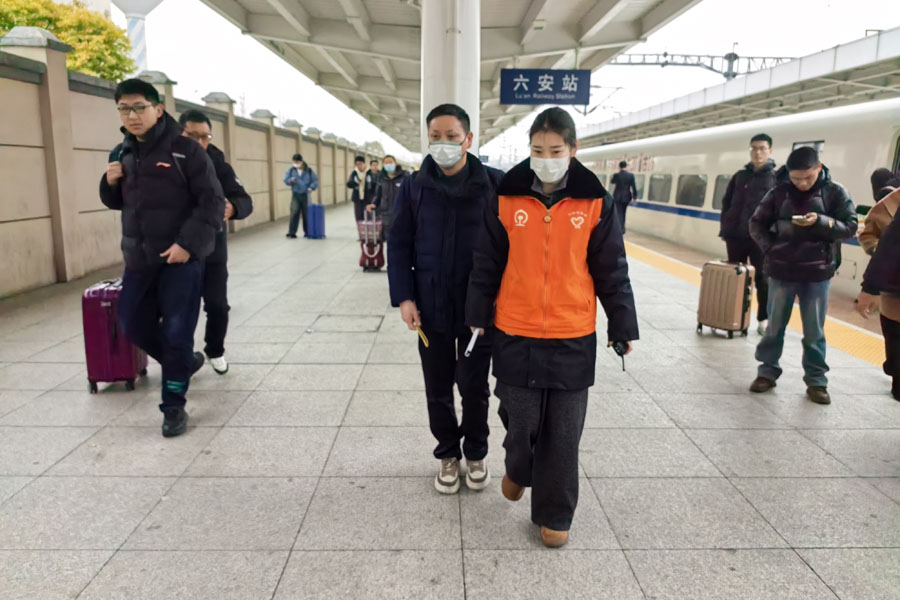 六安站青年志愿者幫助盲人旅客出站。