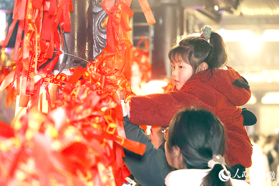 小朋友和家人一起在太平橋上系紅繩。人民網(wǎng)記者 陶濤攝