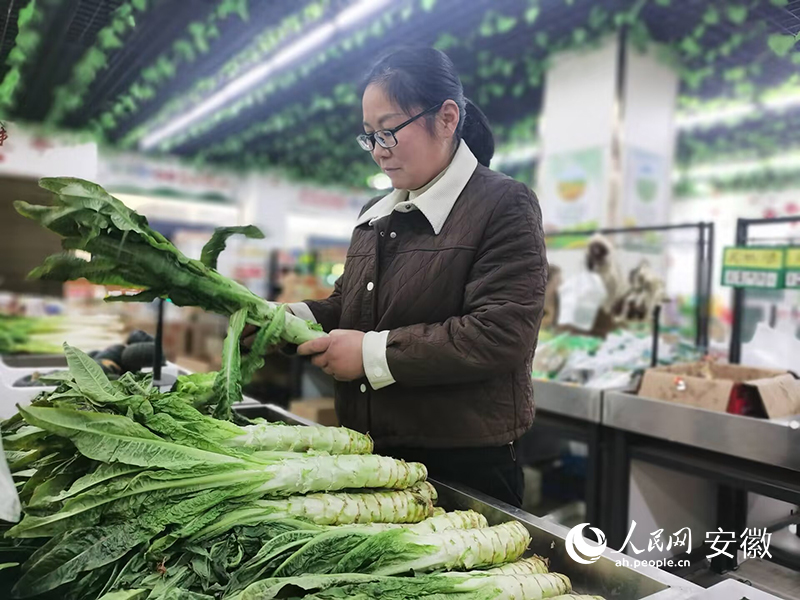 余青青在農(nóng)貿(mào)超市整理蔬菜。人民網(wǎng) 胡雨松攝