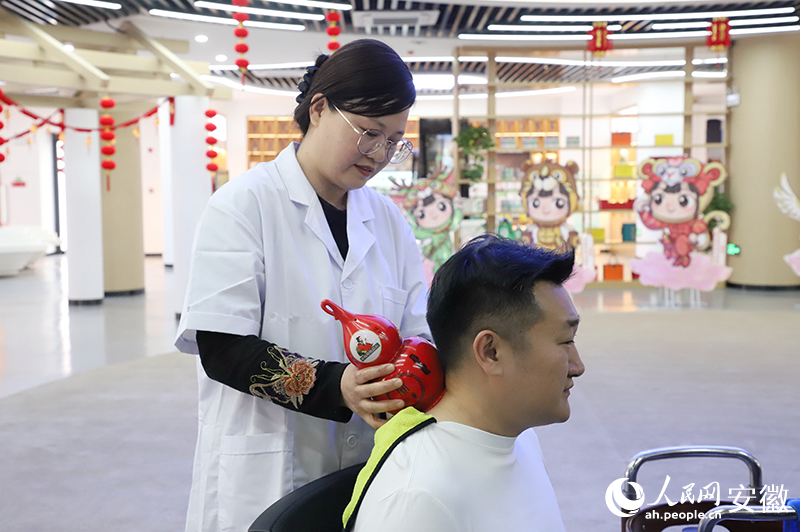 游客在養(yǎng)生會(huì)客廳體驗(yàn)華佗夾脊穴療法。人民網(wǎng) 胡雨松攝.jpg