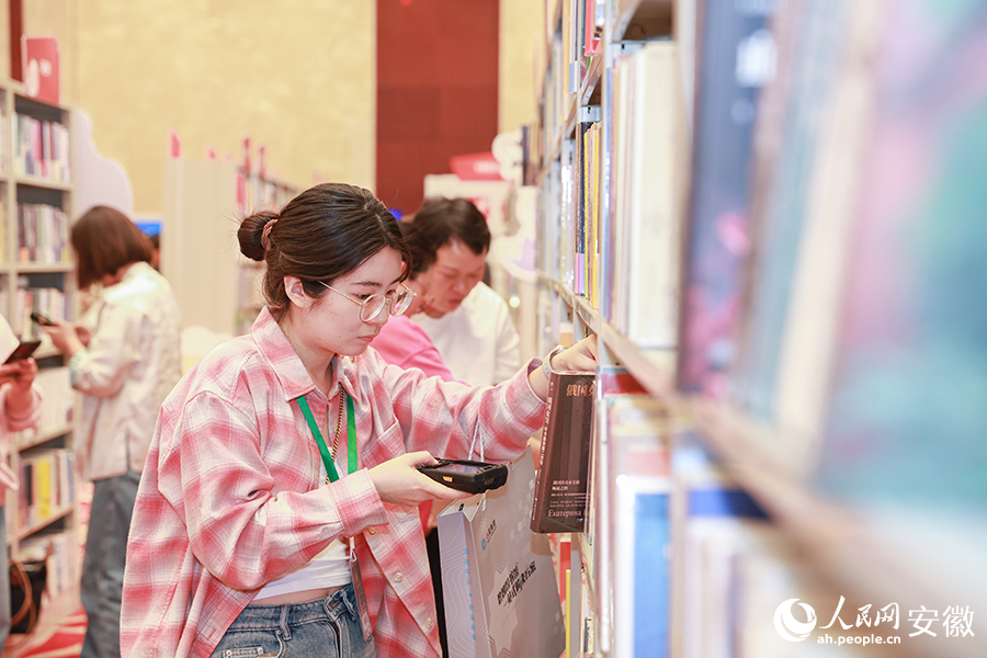 圖書館工作人員在交易大會(huì)上選購圖書。人民網(wǎng)記者 張俊攝