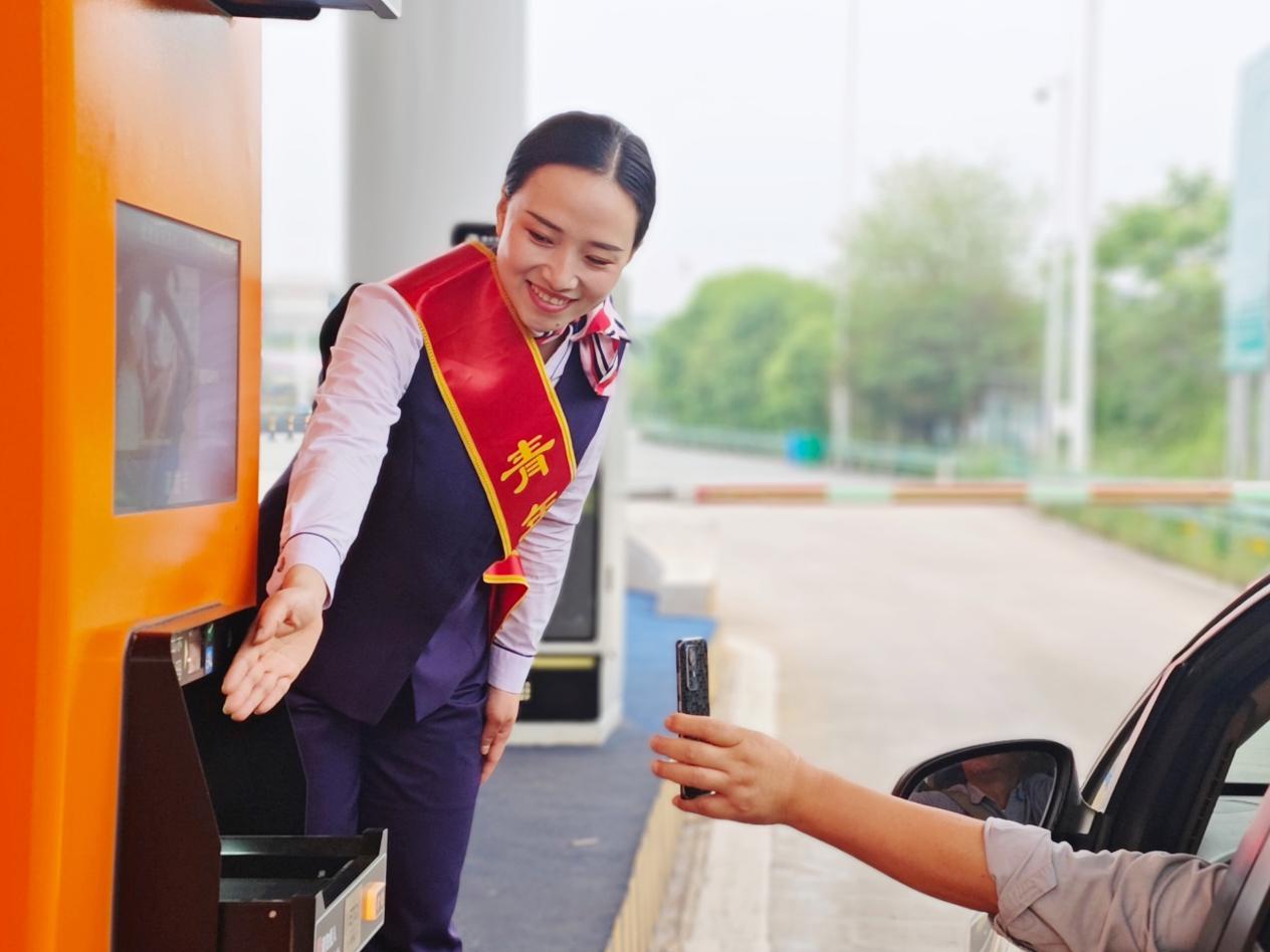 廣德西站青年志愿者指引車主自助繳費。皖通公司供圖