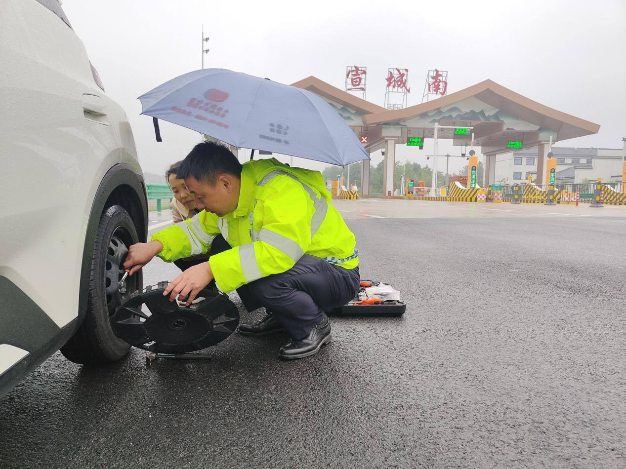 宣城南站收費人員為故障車輛更換備胎。皖通公司供圖