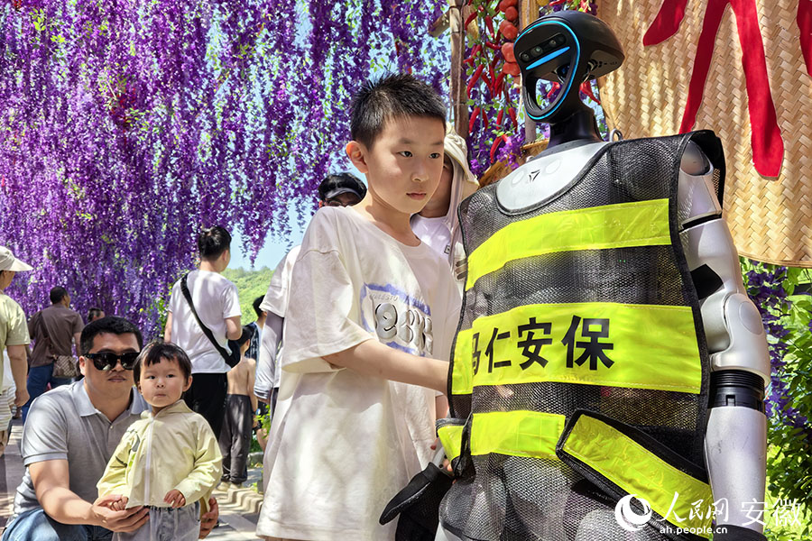 機(jī)器人“上崗”，孩子們爭(zhēng)相合影。人民網(wǎng)記者 汪瑞華攝