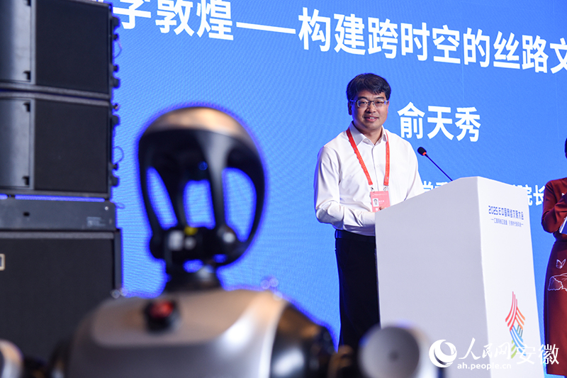 敦煌研究院黨委委員、副院長(zhǎng)俞天秀現(xiàn)場(chǎng)與機(jī)器人互動(dòng)。人民網(wǎng)記者 李希蒙攝