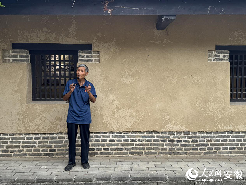 李華松老人為前來參觀的市民作講解。人民網(wǎng) 呂歡歡攝