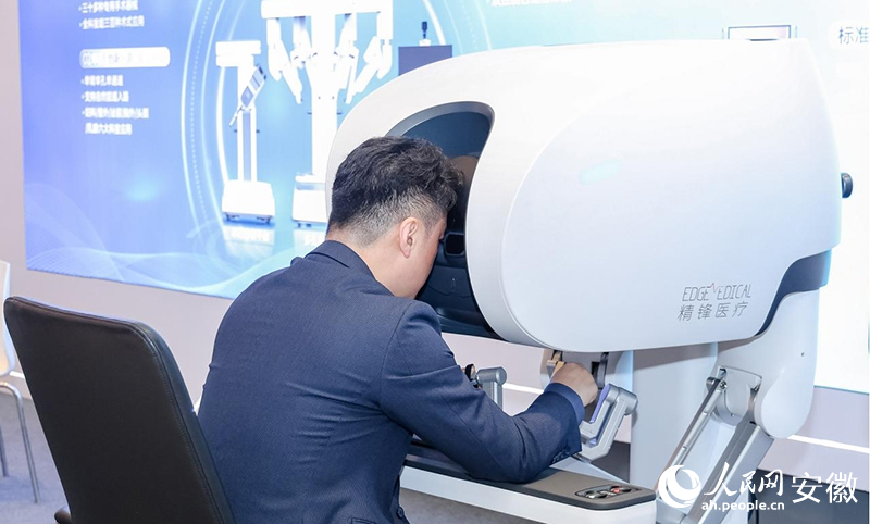 2025全國泌尿外科機器人大會會場外，與會者體驗“手術(shù)機器人”。人民網(wǎng)記者 周坤攝