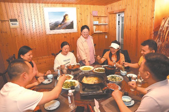 5月16日，葛翔宇抓住上菜時機，聽取游客對臥龍山莊民宿的意見和建議。