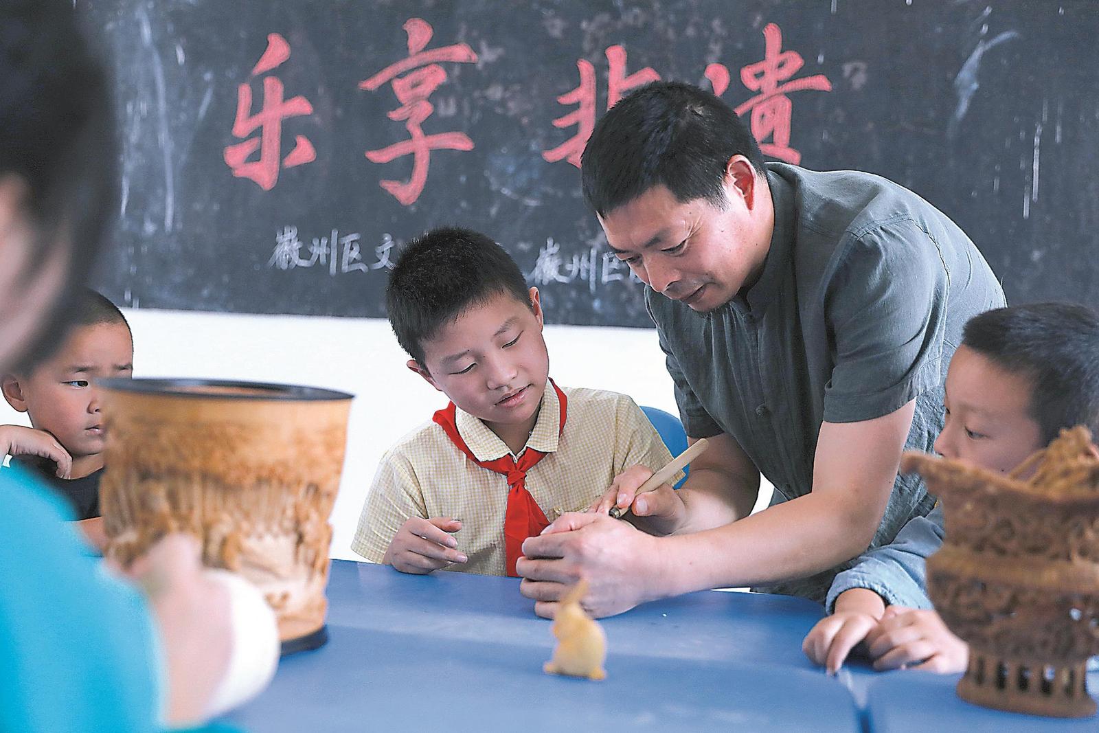 徽州竹雕非遺傳承人洪建華向?qū)W生傳授竹雕技藝。曹曉東 攝